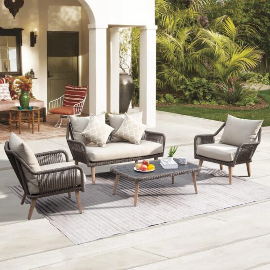 Lou Rodman's furniture range includes outdoor patio seating set with cushioned chairs, loveseat, and coffee table arranged in a modern backyard space.